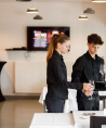 Deux jeunes en train de préparer une table de restaurant 